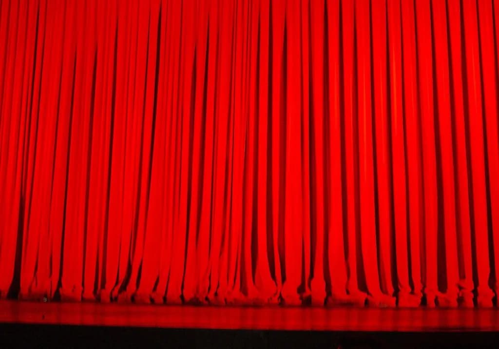 Red velvet stage curtain hanging in deep folds