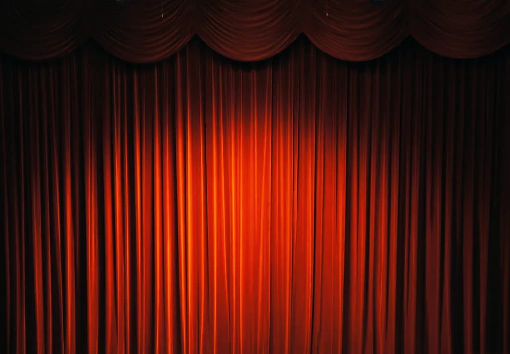 Red stage curtain with a swagged valance across the top