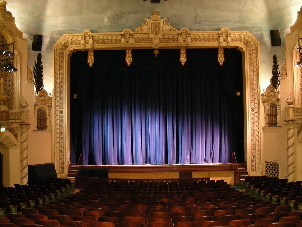 Theatre stage with a closed front curtain seen from the auditorium