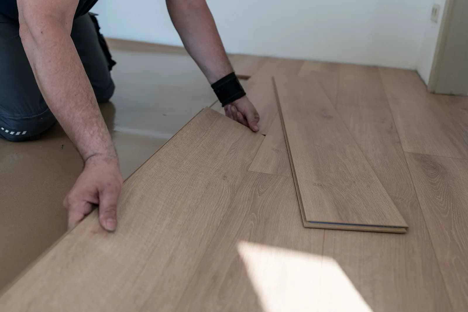 Click flooring planks being locked together during installation