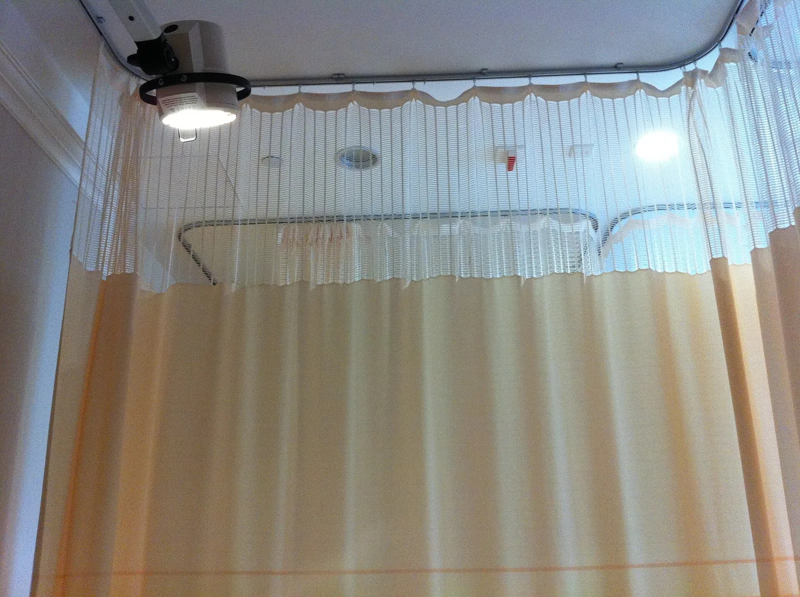 Cubicle curtain with a mesh top hung from a curved ceiling track