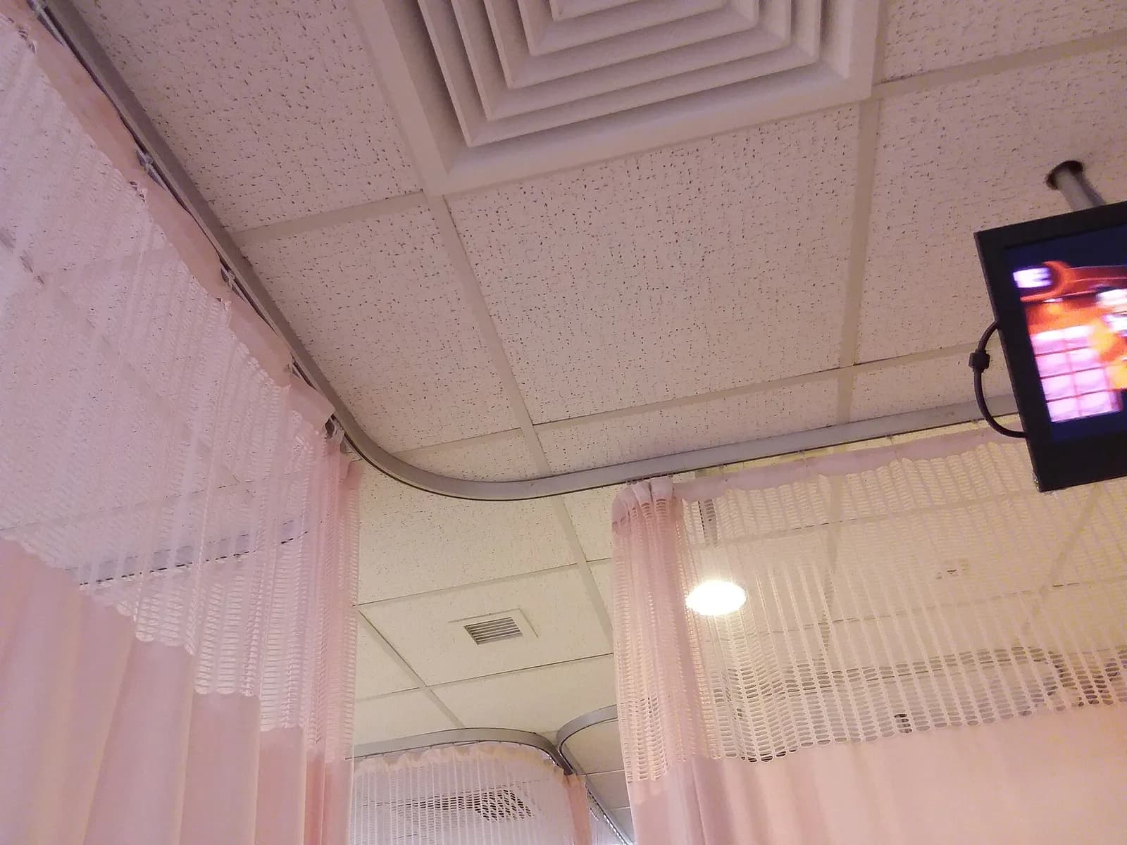 Pink cubicle curtains on ceiling tracks in a hospital ward
