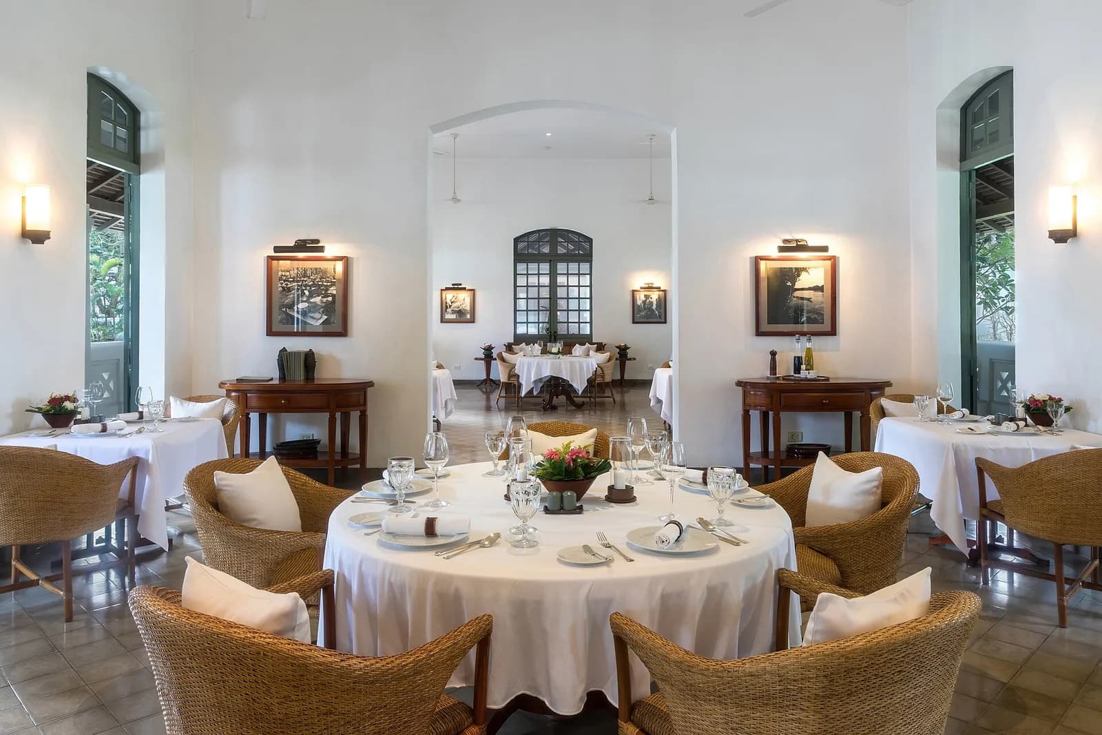 Restaurant with round tables and cane armchairs with cushions
