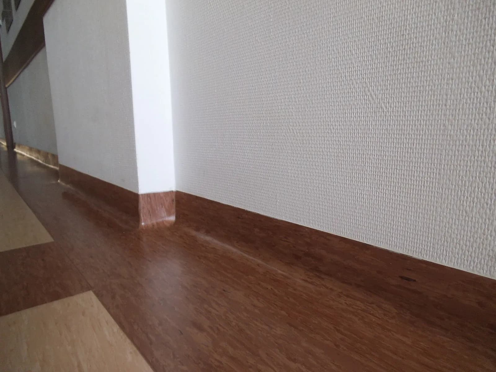 Wood-look floor finished with a matching skirting at the wall