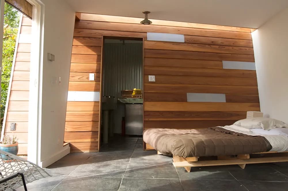 Bedroom with a wall clad in horizontal wood panels