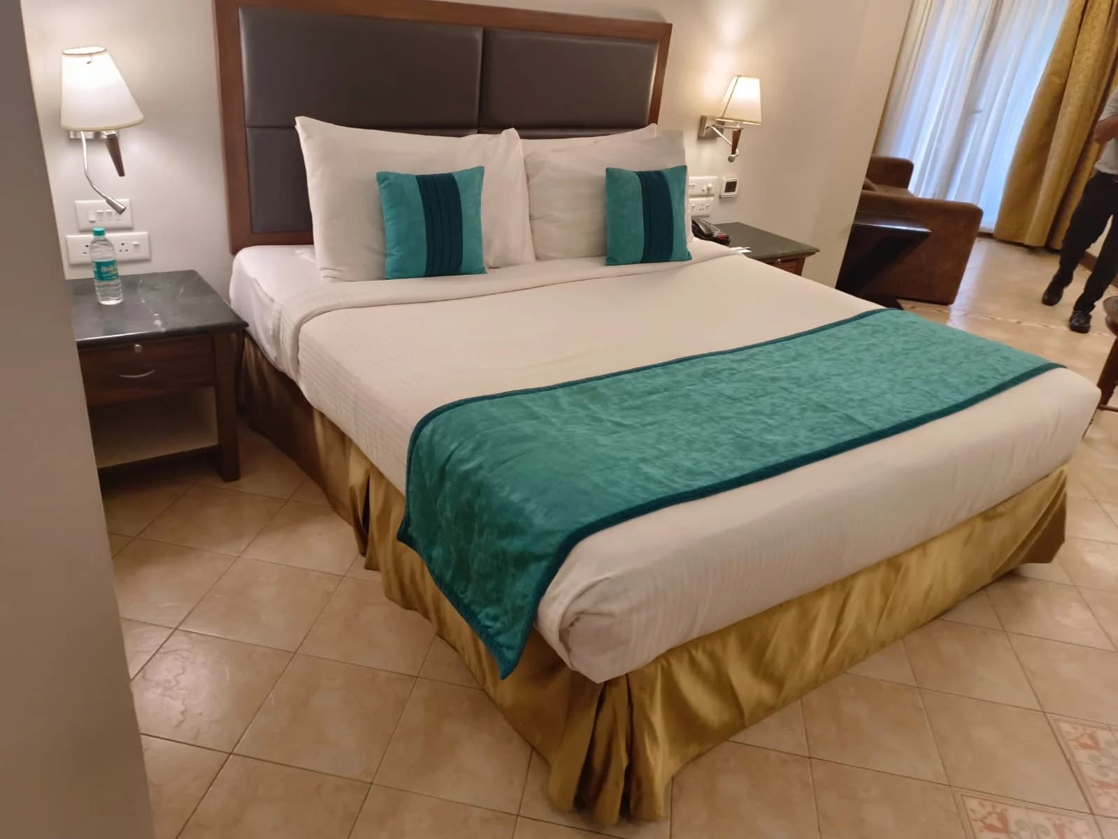 Resort bedroom with an upholstered headboard and teal runner