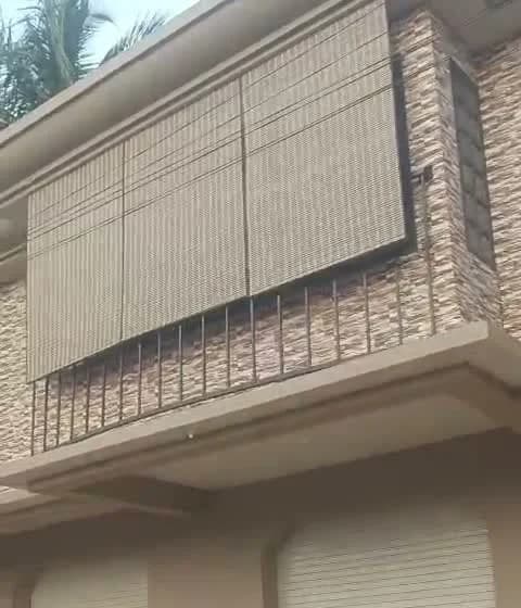 PVC chick blinds hanging outside a first-floor balcony with a metal railing in Margao