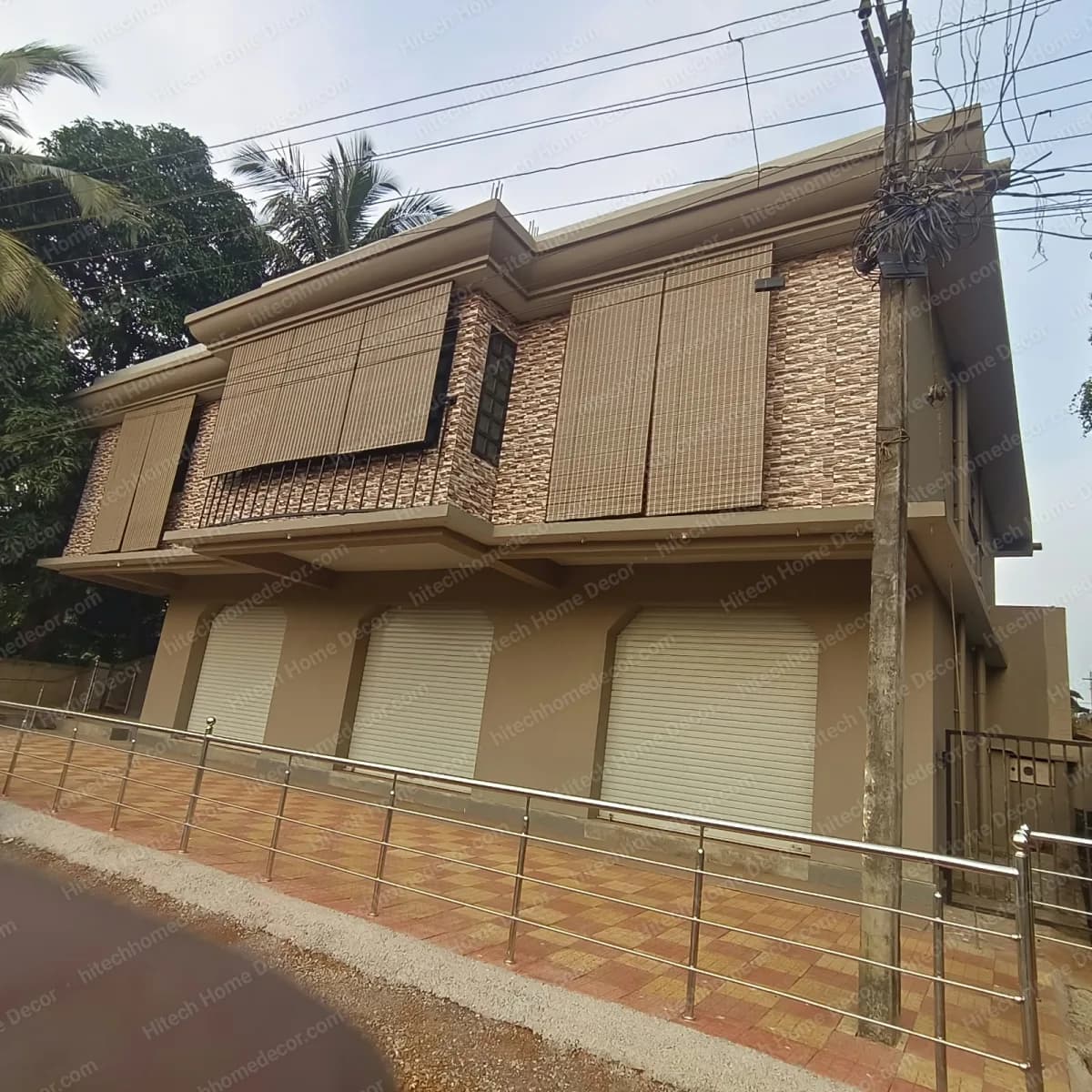 Road-facing building in Margao with PVC chick blinds on the first floor and shop shutters on the ground floor