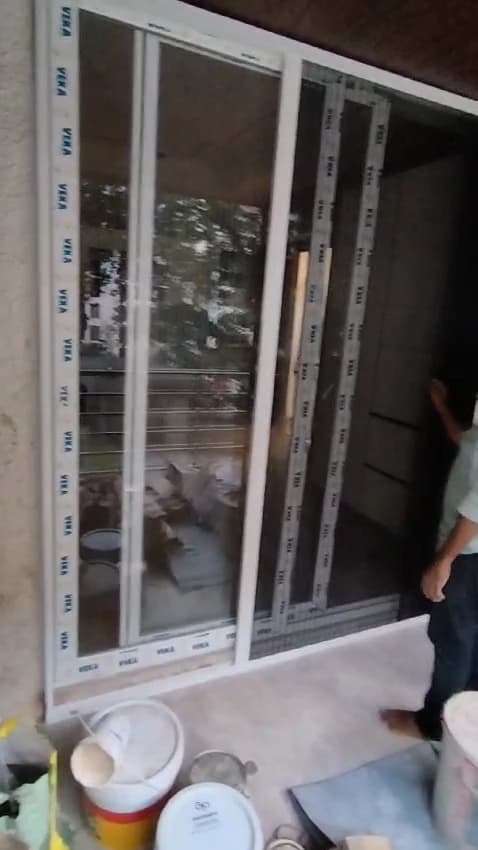 Sliding mosquito net frame fitted flush against a balcony sliding door in Margao