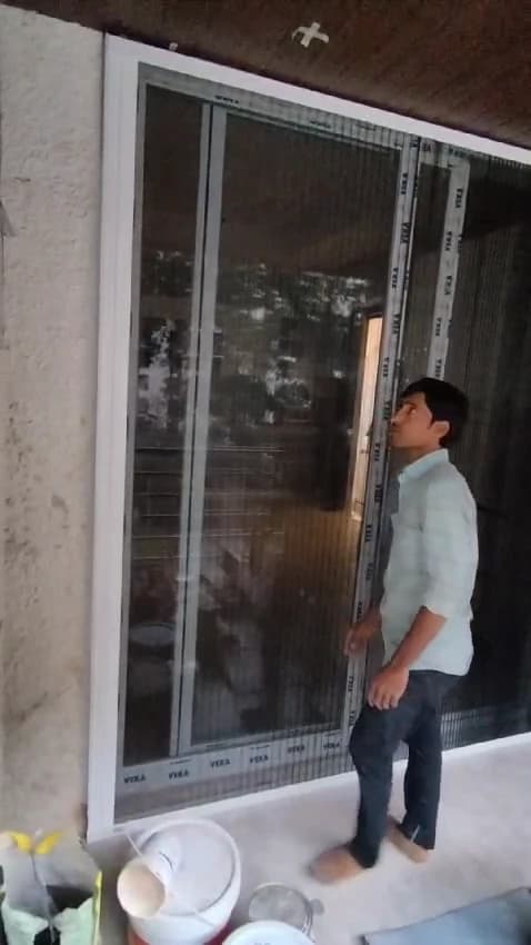 Technician checking the glide of the pleated mosquito net after fitting